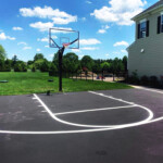 Precise basketball court layout striping completed by Davis Line Striping at a private home. Residential basketball court with freshly painted white lines