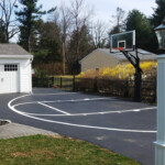 Driveway basketball court with half-court striping completed by Davis Line Striping for a suburban home. Half-court basketball striping on a residential driveway